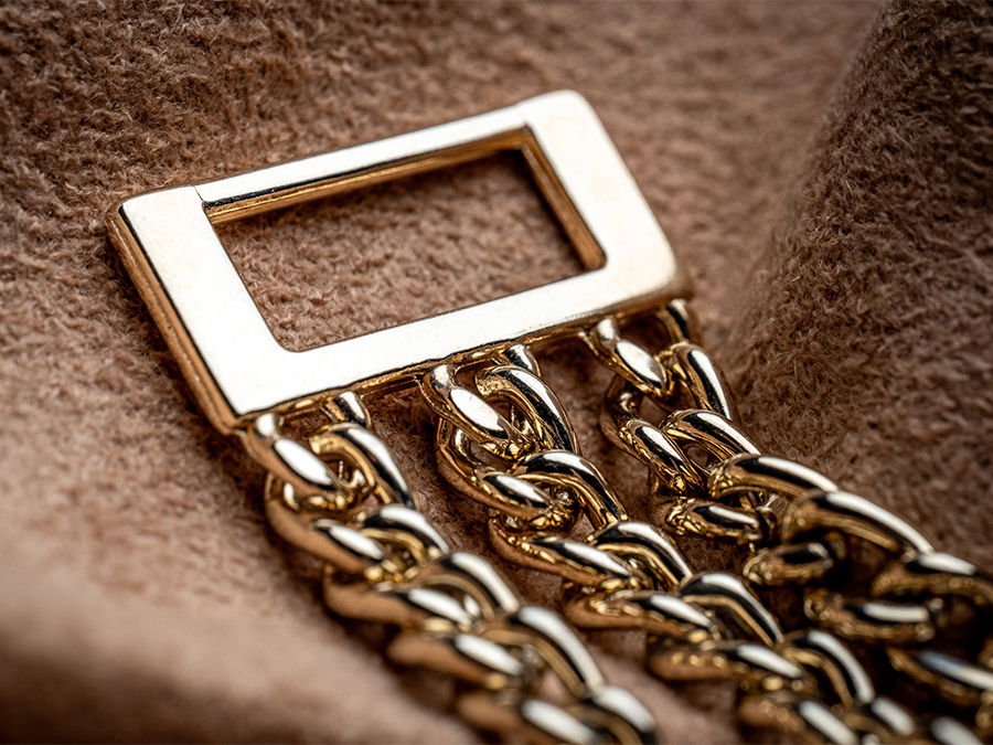 Accessorio in metallo color oro con catenella decorativa